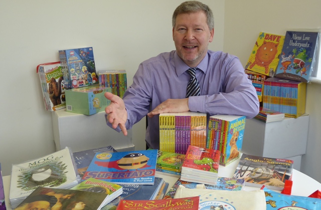 Simon Dolby, chief executive of the KM Charity Team, with the books to be won by a school joining the charity’s green travel scheme.